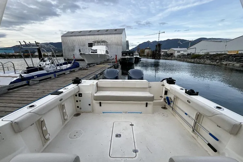  Yacht Photos Pics 2014 Pursuit OS 285 Offshore boat docked at a marina with scenic mountain backdrop.