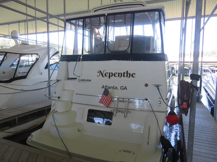 Nepenthe Yacht Photos Pics 2003 Carver 366 Motor Yacht docked, rear view with "Nepenthe" name and American flag.
