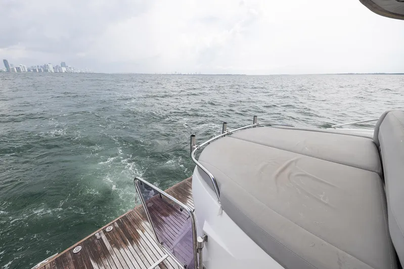 Perseverance Yacht Photos Pics 2014 Beneteau Gran Turismo 44 yacht on open water, city skyline in background.