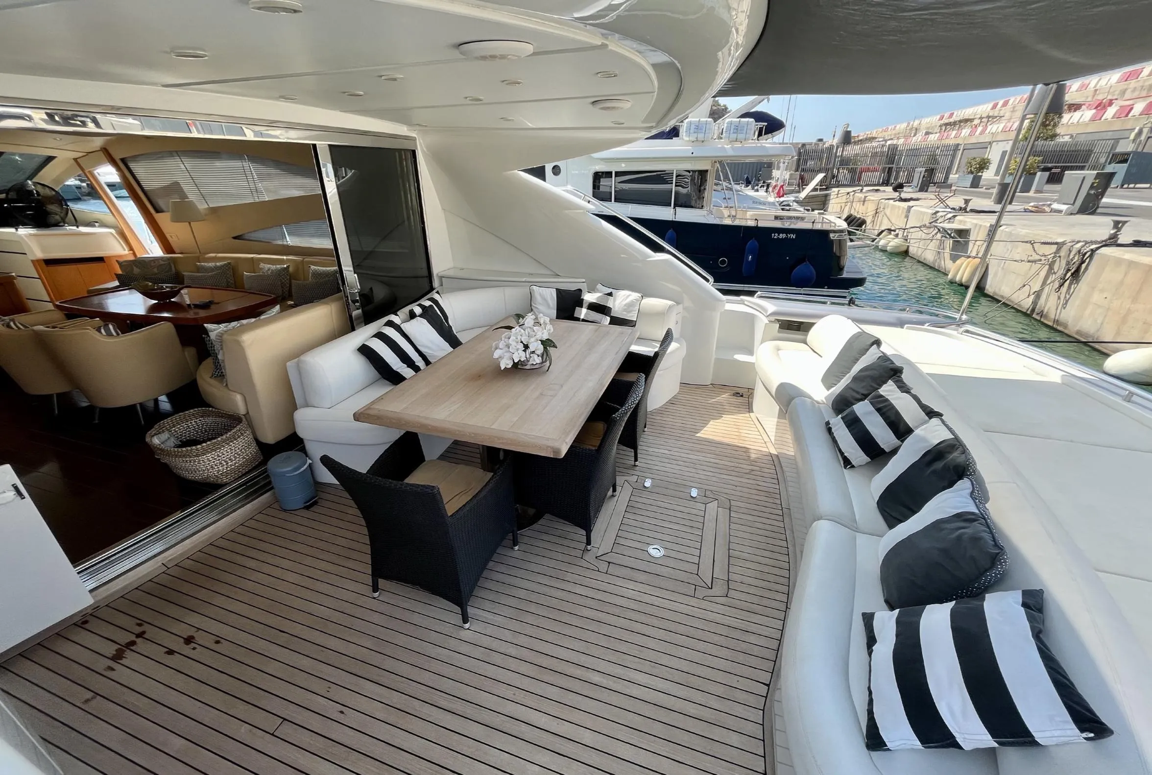 Luxurious 2005 Pershing 76 yacht deck with elegant seating and dining area.