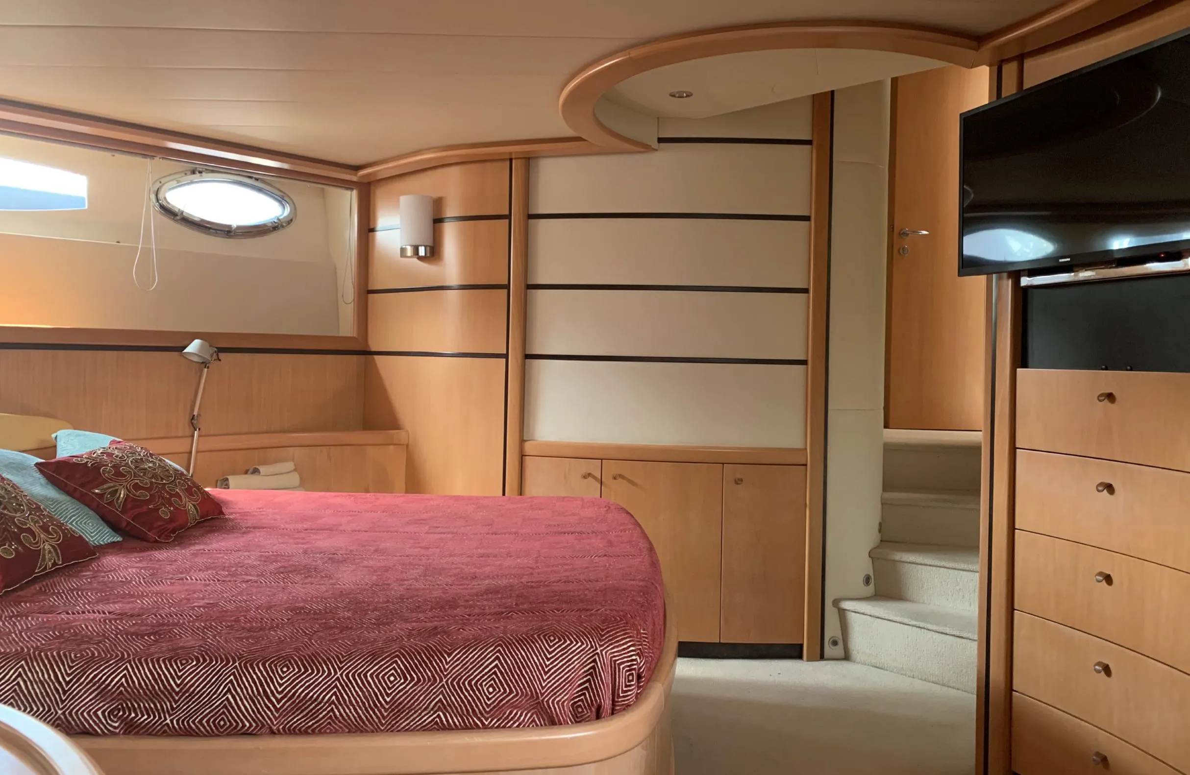 Luxurious 2005 Pershing 76 yacht bedroom with elegant wood paneling and modern furnishings.