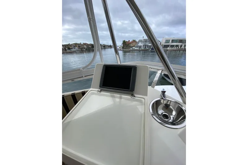  Yacht Photos Pics Helm of 2012 Mikelson 43 Sportfisher with navigation screen and sink, overlooking marina.