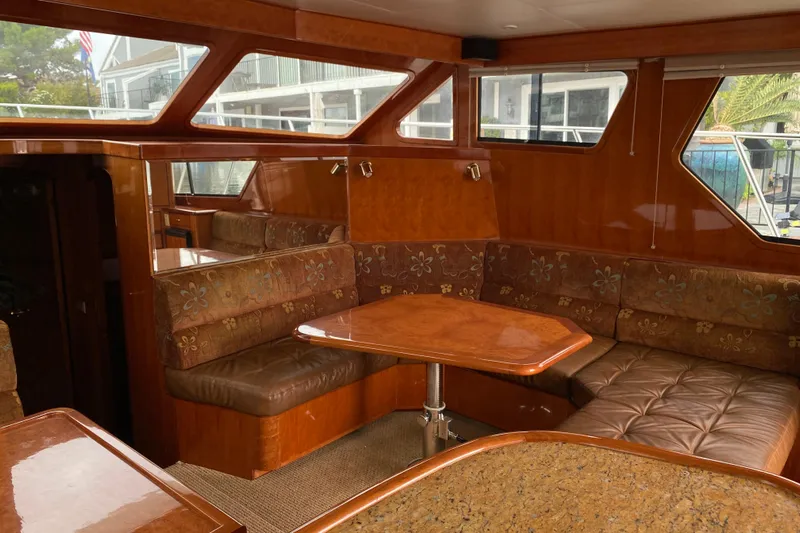  Yacht Photos Pics Luxurious interior of 2012 Mikelson 43 Sportfisher yacht with plush seating and wooden table.