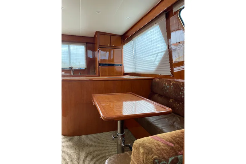  Yacht Photos Pics Interior of 2012 Mikelson 43 Sportfisher yacht with wooden table and seating area.