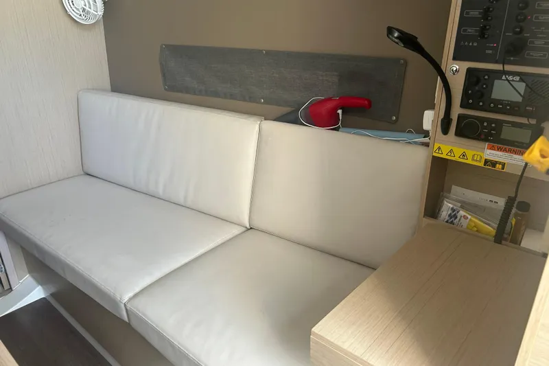 Al Di La Yacht Photos Pics Interior of 2020 Beneteau Oceanis 30.1 yacht with white seating and control panel.