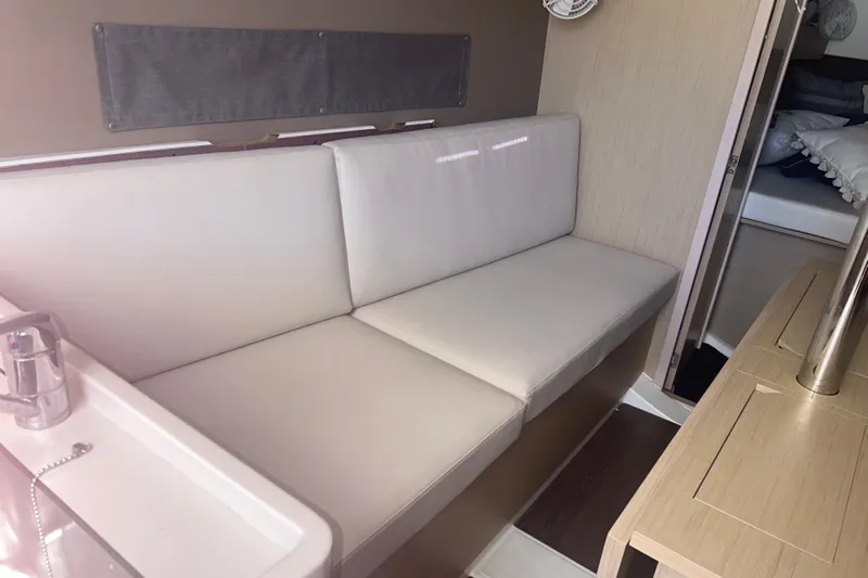 Al Di La Yacht Photos Pics Interior of 2020 Beneteau Oceanis 30.1 yacht with white seating and wooden accents.