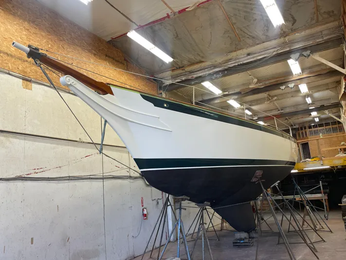 "warm Rain Ii" Yacht Photos Pics Custom Bruce King 1992 sailboat in a workshop, elevated on stands.