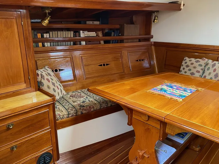 "warm Rain Ii" Yacht Photos Pics Cozy wooden yacht interior with built-in seating, table, and bookshelf, Custom Bruce King 1992 model.