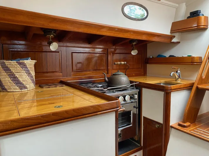 "warm Rain Ii" Yacht Photos Pics Custom 1992 Bruce King yacht kitchen with wooden cabinetry, stove, and sink.