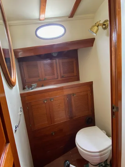 "warm Rain Ii" Yacht Photos Pics 1992 Custom Bruce King boat bathroom with wooden cabinets and nautical decor.