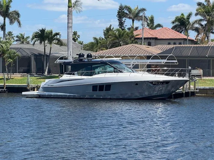  Yacht Photos Pics 2014 Cruisers Yachts 45 Cantius Black Diamond docked by waterfront homes.