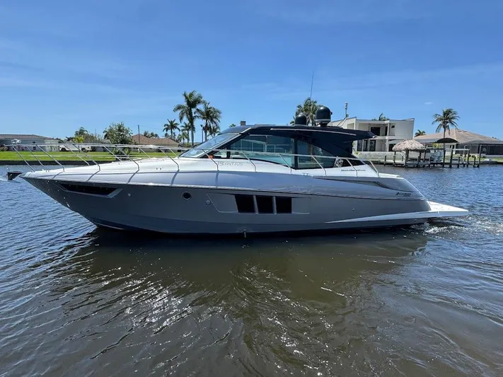  Yacht Photos Pics 2014 Cruisers Yachts 45 Cantius Black Diamond on water, with palm trees in background.