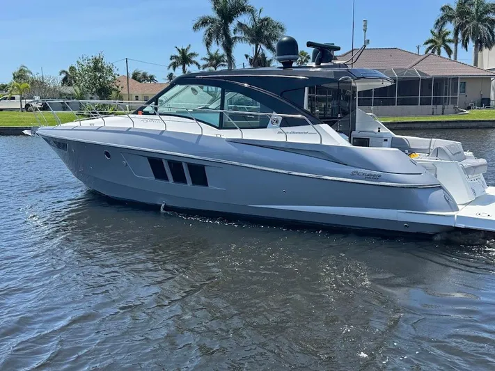  Yacht Photos Pics 2014 Cruisers Yachts 45 Cantius Black Diamond on water, sleek design, palm trees in background.