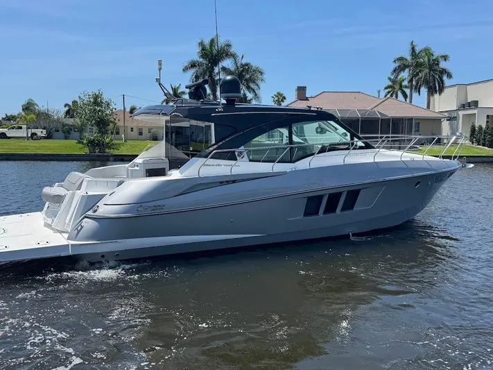  Yacht Photos Pics 2014 Cruisers Yachts 45 Cantius Black Diamond on water near waterfront homes.