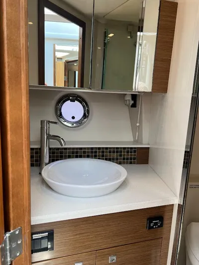  Yacht Photos Pics 2014 Cruisers Yachts 45 Cantius Black Diamond bathroom with modern sink and porthole window.