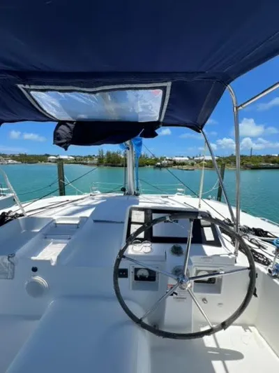 Kajsa Yacht Photos Pics 2017 Lagoon 450 F yacht helm with blue canopy, docked by serene waters.