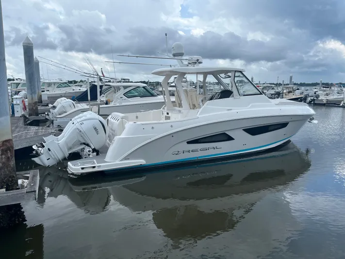 Don't Stop Believin Yacht Photos Pics 2022 Regal 33 SAV boat docked at a marina on a cloudy day.