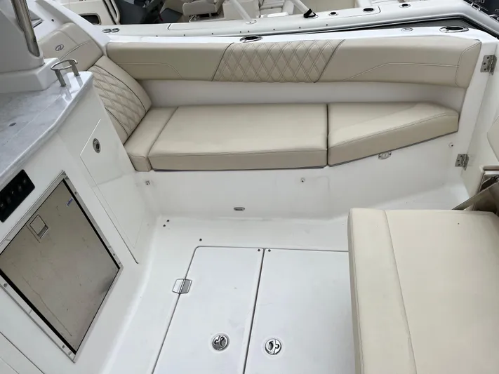 Don't Stop Believin Yacht Photos Pics 2022 Regal 33 SAV boat interior with beige seating and storage compartments.