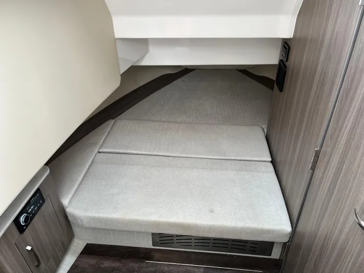 Don't Stop Believin Yacht Photos Pics 2022 Regal 33 SAV cabin interior with cushioned seating and modern wood paneling.