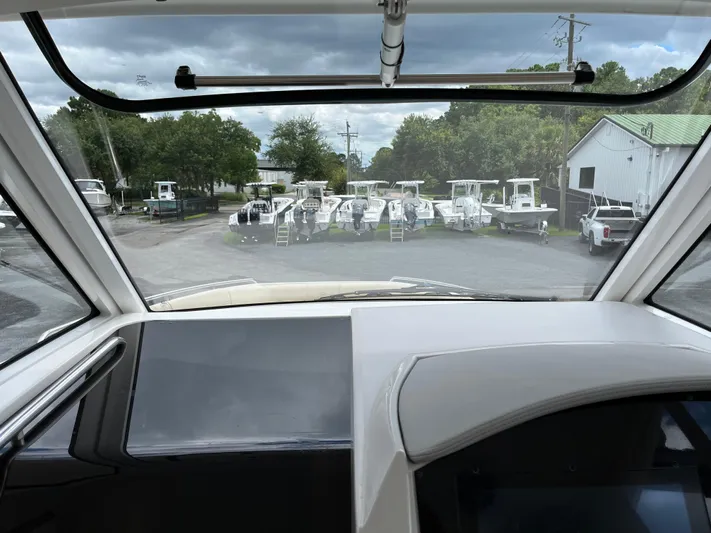 Don't Stop Believin Yacht Photos Pics View from 2022 Regal 33 SAV boat cockpit, overlooking parked boats and cloudy sky.