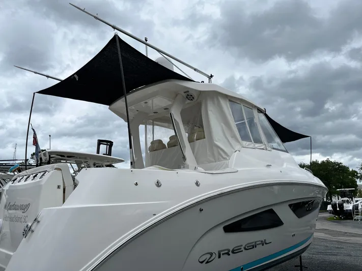 Don't Stop Believin Yacht Photos Pics 2022 Regal 33 SAV boat with canopy under cloudy sky.
