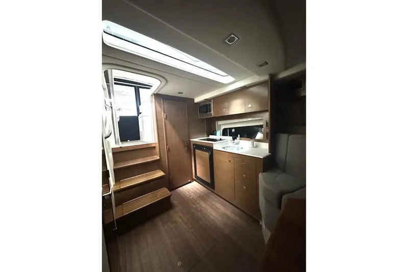 Branch Office Yacht Photos Pics 2016 Cruisers 390 Express yacht interior with wooden cabinetry and modern kitchen amenities.