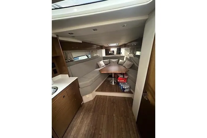 Branch Office Yacht Photos Pics 2016 Cruisers 390 Express interior with cozy seating and wooden flooring.