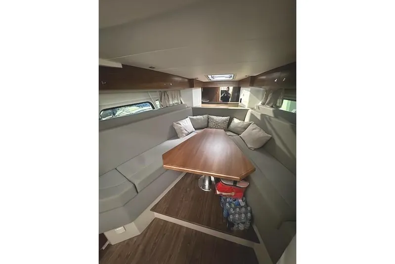 Branch Office Yacht Photos Pics 2016 Cruisers 390 Express interior with cozy seating and wooden table.