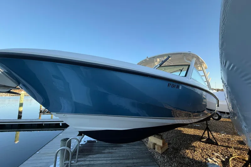  Yacht Photos Pics 2017 Boston Whaler 320 Vantage boat docked, showcasing sleek blue hull design.
