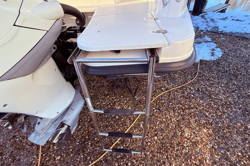  Yacht Photos Pics 2017 Boston Whaler 320 Vantage boat with a retractable swim ladder on gravel.