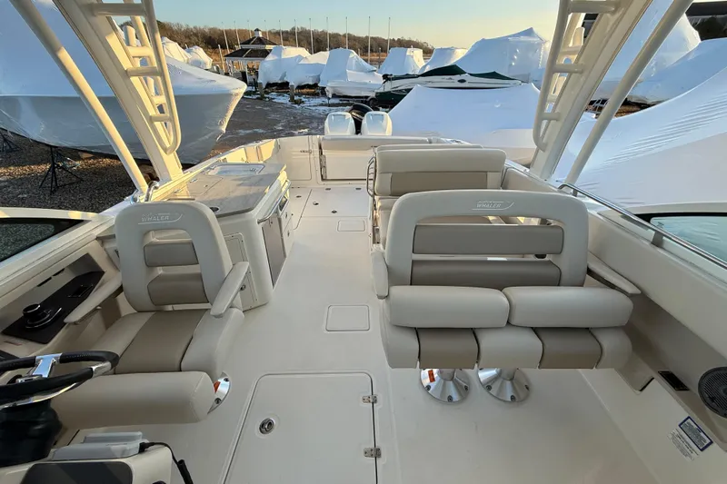  Yacht Photos Pics 2017 Boston Whaler 320 Vantage interior with seating and helm, docked among covered boats.