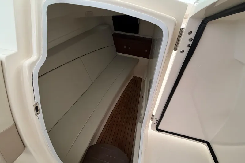  Yacht Photos Pics 2017 Boston Whaler 320 Vantage cabin interior with seating and wooden flooring.