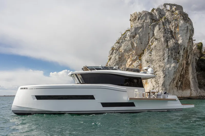  Yacht Photos Pics 2026 Pardo Yachts E60 cruising near a rocky cliff under a cloudy sky.