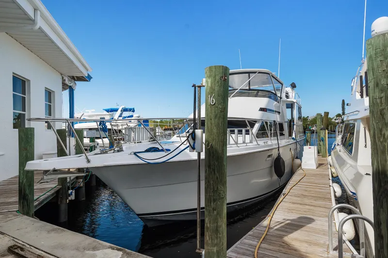 Yacht Photos Pics 1999 Hatteras 52 Cockpit Motor Yacht docked at marina, clear blue sky.