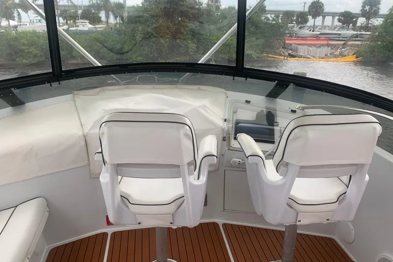 Yacht Photos Pics Cockpit view of 1999 Hatteras 52 Cockpit Motor Yacht with white seating and wood flooring.