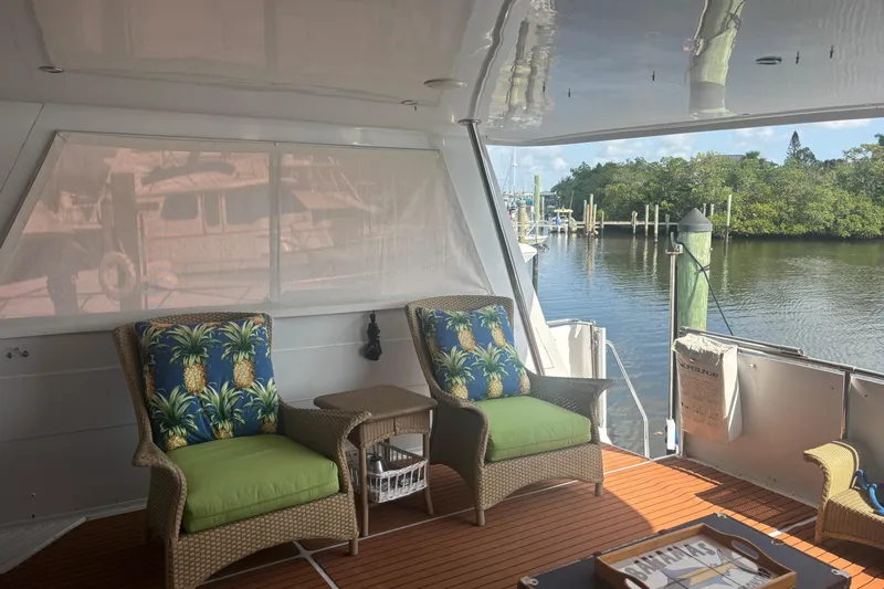  Yacht Photos Pics 1999 Hatteras 52 Cockpit Motor Yacht interior with tropical-themed seating and waterfront view.