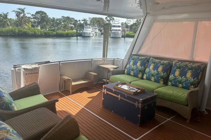  Yacht Photos Pics 1999 Hatteras 52 Cockpit Motor Yacht interior with tropical-themed seating and waterfront view.