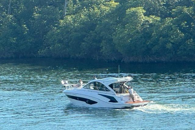 2023 Evolve 400HT yacht cruising on a serene, tree-lined waterway.