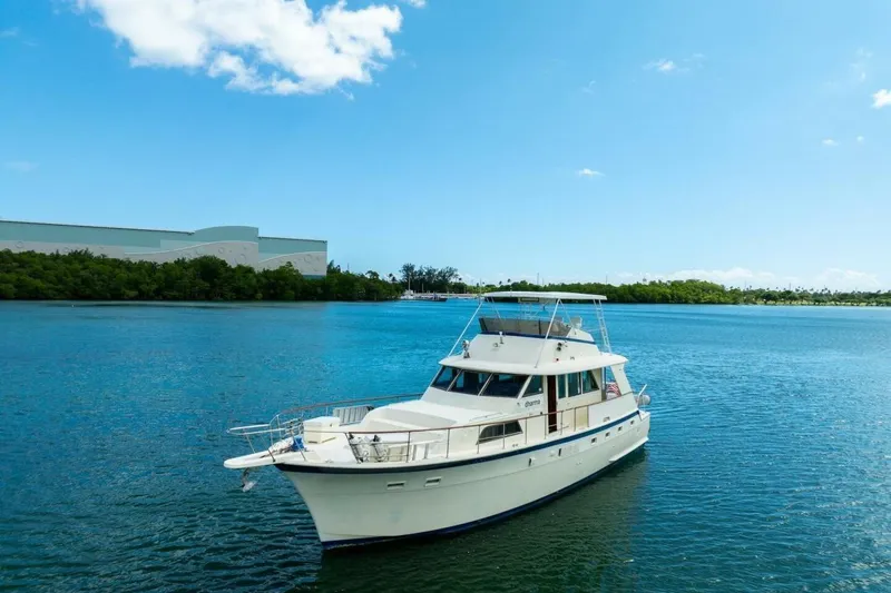 Dharma Yacht Photos Pics 1978 Hatteras 53 Yacht Fisherman on serene blue water under clear sky.