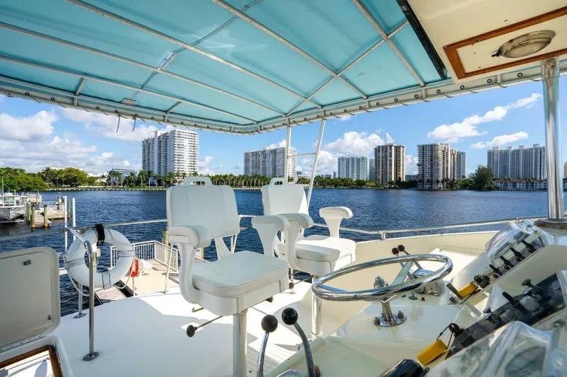 Dharma Yacht Photos Pics 1978 Hatteras 53 Yacht Fisherman helm with city skyline and waterfront view.