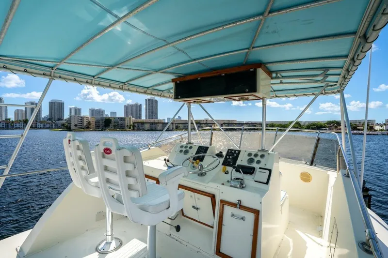 Dharma Yacht Photos Pics 1978 Hatteras 53 Yacht Fisherman helm with city skyline and water view.