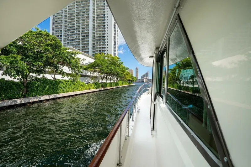 Dharma Yacht Photos Pics 1978 Hatteras 53 Yacht Fisherman cruising along a scenic urban waterway.