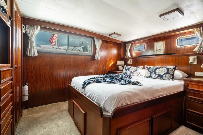 Dharma Yacht Photos Pics Luxurious cabin interior of 1978 Hatteras 53 Yacht Fisherman with wood paneling and cozy bedding.
