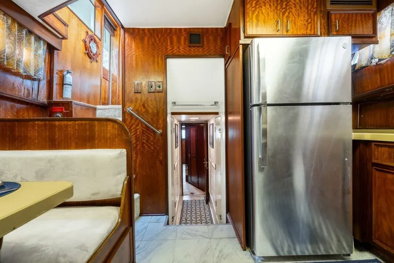 Dharma Yacht Photos Pics 1978 Hatteras 53 Yacht Fisherman interior with wood paneling and stainless steel refrigerator.