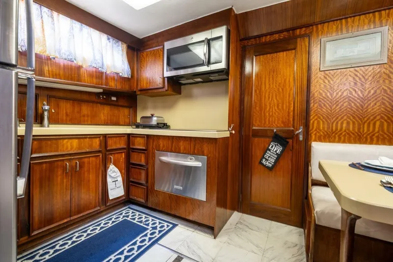 Dharma Yacht Photos Pics 1978 Hatteras 53 Yacht Fisherman kitchen with wood cabinetry and modern appliances.