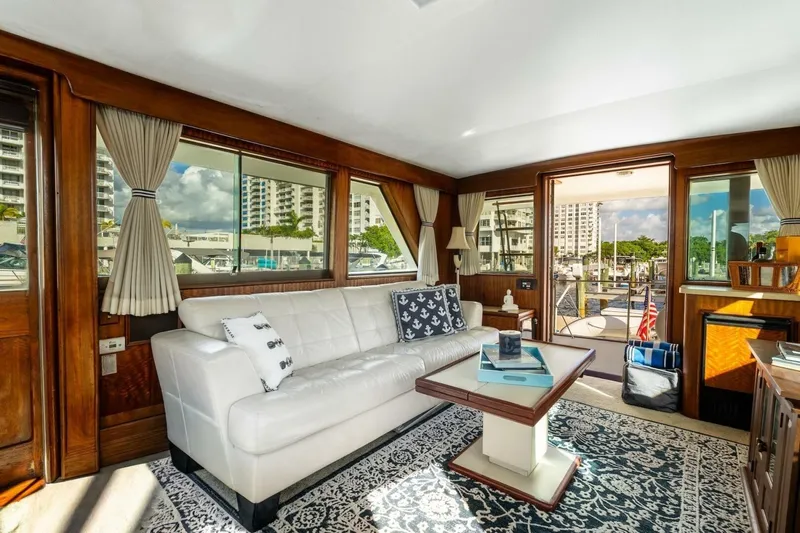 Dharma Yacht Photos Pics Luxurious interior of 1978 Hatteras 53 Yacht Fisherman with elegant furnishings and marina view.