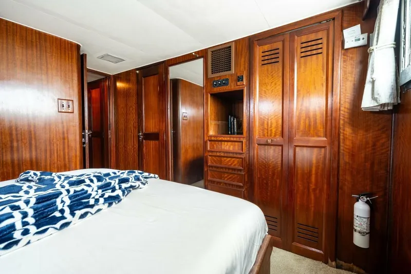 Dharma Yacht Photos Pics 1978 Hatteras 53 Yacht Fisherman cabin with wood paneling and cozy bedding.