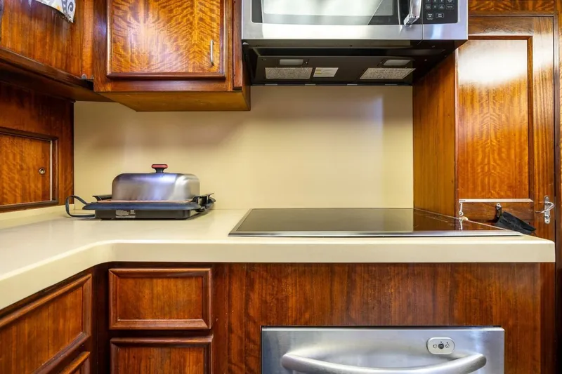 Dharma Yacht Photos Pics 1978 Hatteras 53 Yacht Fisherman kitchen with wooden cabinets and modern appliances.