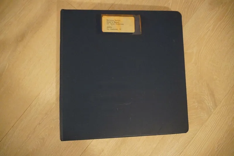 Dharma Yacht Photos Pics Black binder labeled "Hatteras 53 Yacht Fisherman 1978" on wooden floor.