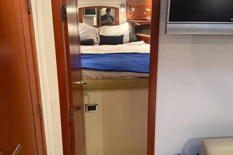 Fresh Off The Boat Yacht Photos Pics Interior cabin of 2008 Four Winns 378 Vista yacht with bed and wooden finishes.